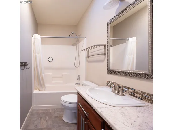 a bathroom with a granite countertop sink toilet a shower and a mirror