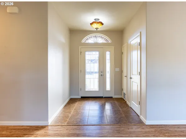 an empty room with wooden floor and window