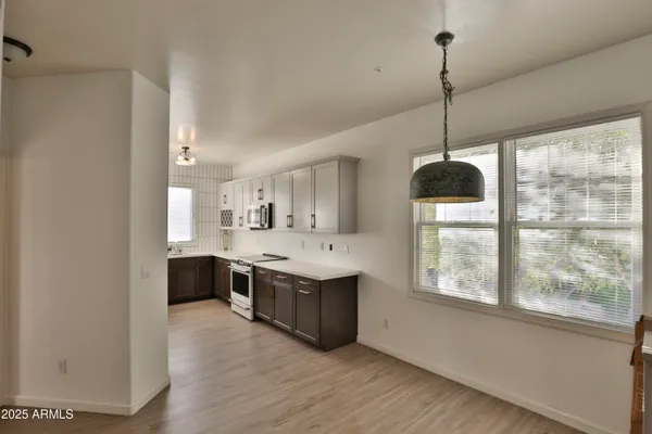 a view of kitchen with stainless steel appliances granite countertop a sink and wooden floor