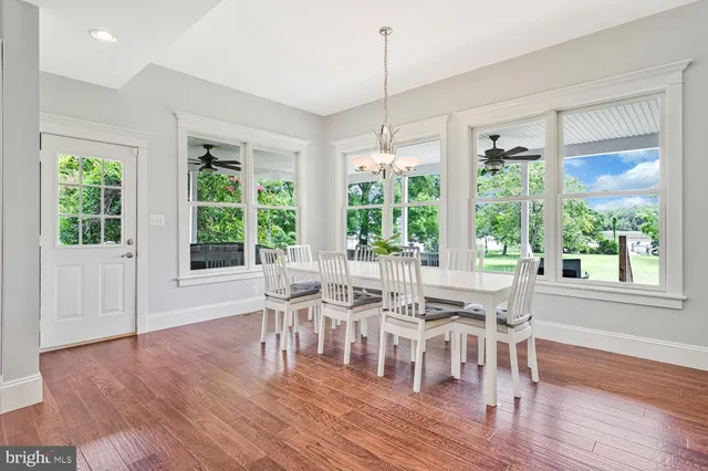 a kitchen with kitchen island wooden floors white appliances and windows