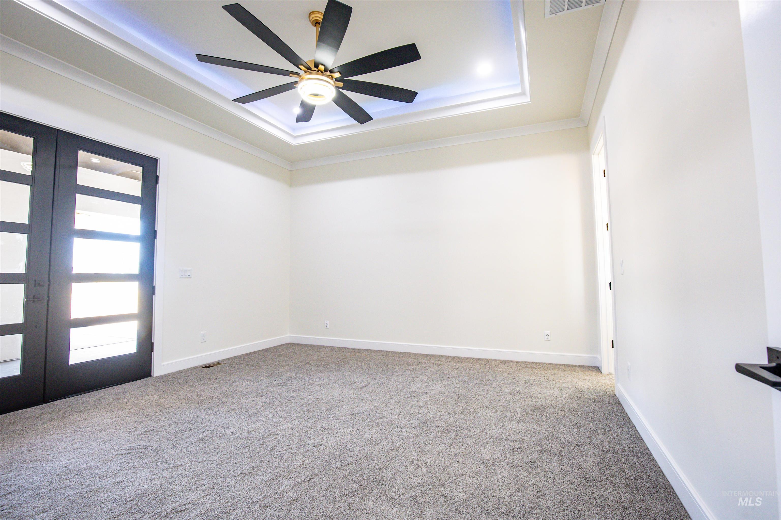 23904 Southview Lane Middleton, ID 83644 - Photo 8 of 29 Spacious room featuring a tray ceiling with recessed lighting, a multi-blade ceiling fan, and crown molding