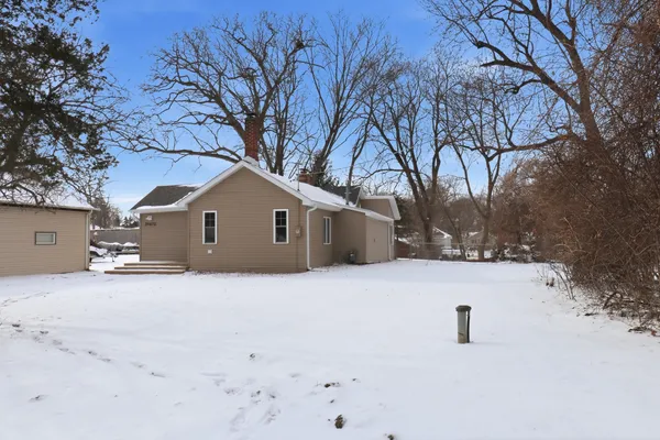 a front view of a house with a yard covered in snow