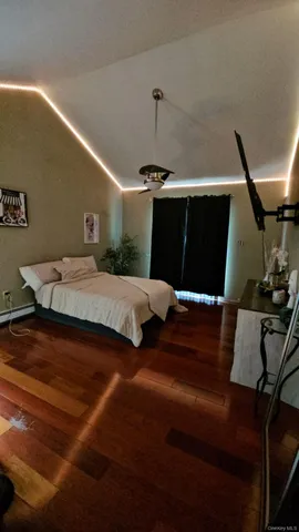 a bedroom with bed and wooden floor