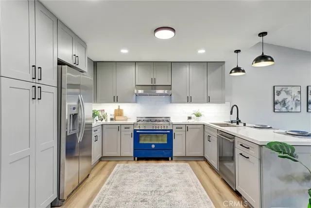 a kitchen with stainless steel appliances granite countertop a sink stove and refrigerator