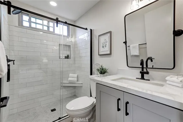 a bathroom with a sink a toilet and shower