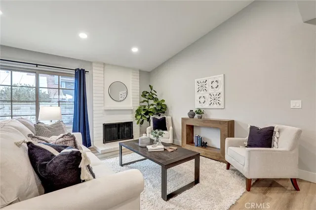 a living room with furniture a fireplace and a large window
