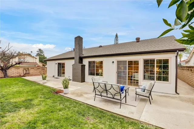 a view of a house with backyard and sitting area