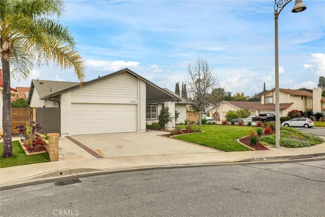a view of a house with a yard and palm trees