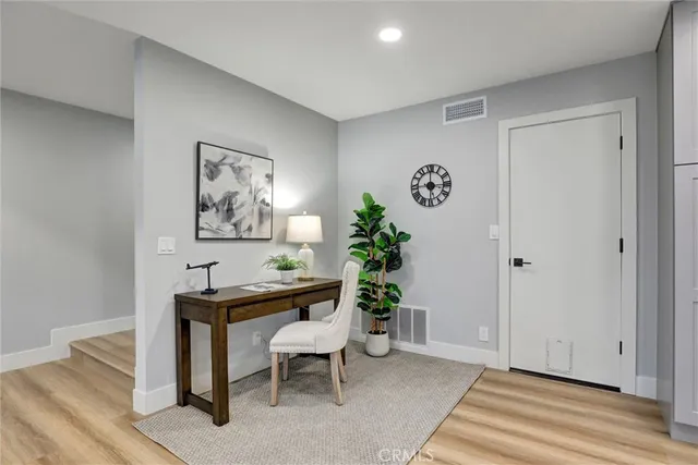 a view of a workspace with furniture and wooden floor
