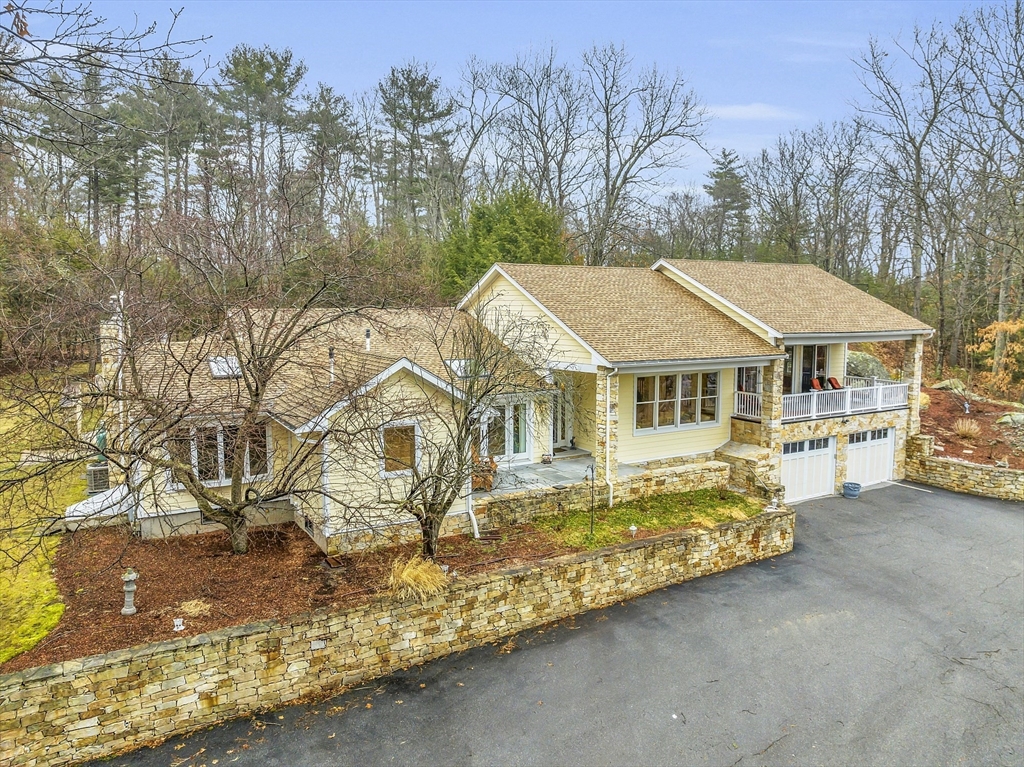 a aerial view of a house with yard and trees in the background