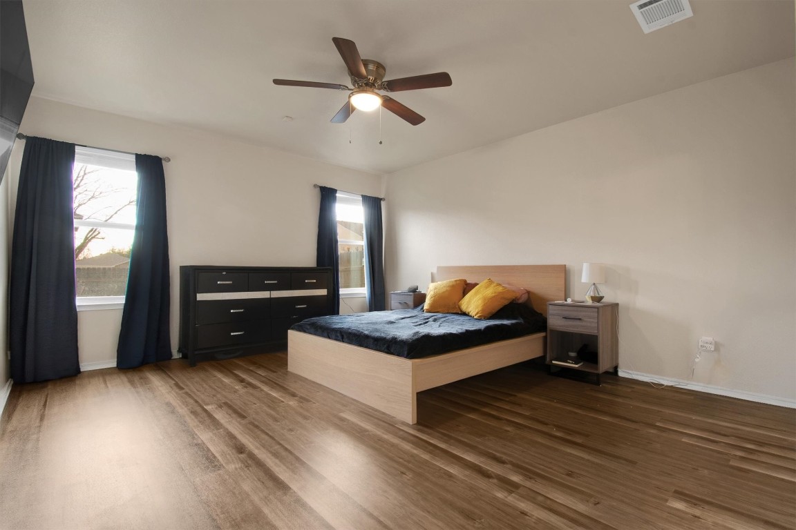 18205 Topsail Street Manor, TX 78653 - Photo 15 of 29 Bedroom with multiple windows, wood finished floors, and ceiling fan