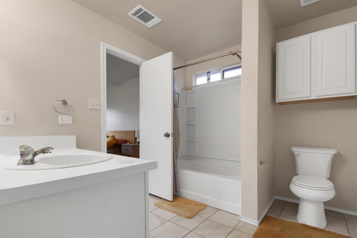 18205 Topsail Street Manor, TX 78653 - Photo 18 of 29 Bathroom featuring vanity, light tile patterned flooring, and shower / bath combo