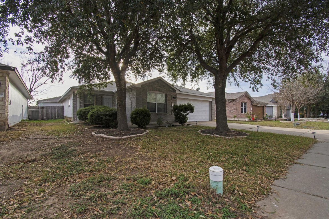 18205 Topsail Street Manor, TX 78653 - Photo 2 of 29 Ranch-style house featuring concrete driveway, a garage, and brick siding