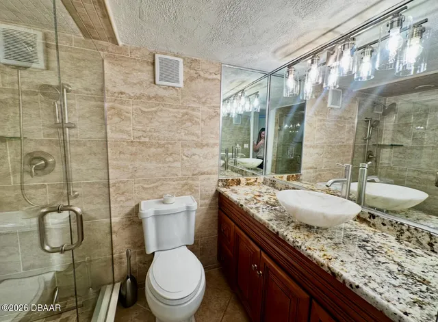a bathroom with a granite countertop toilet sink and mirror