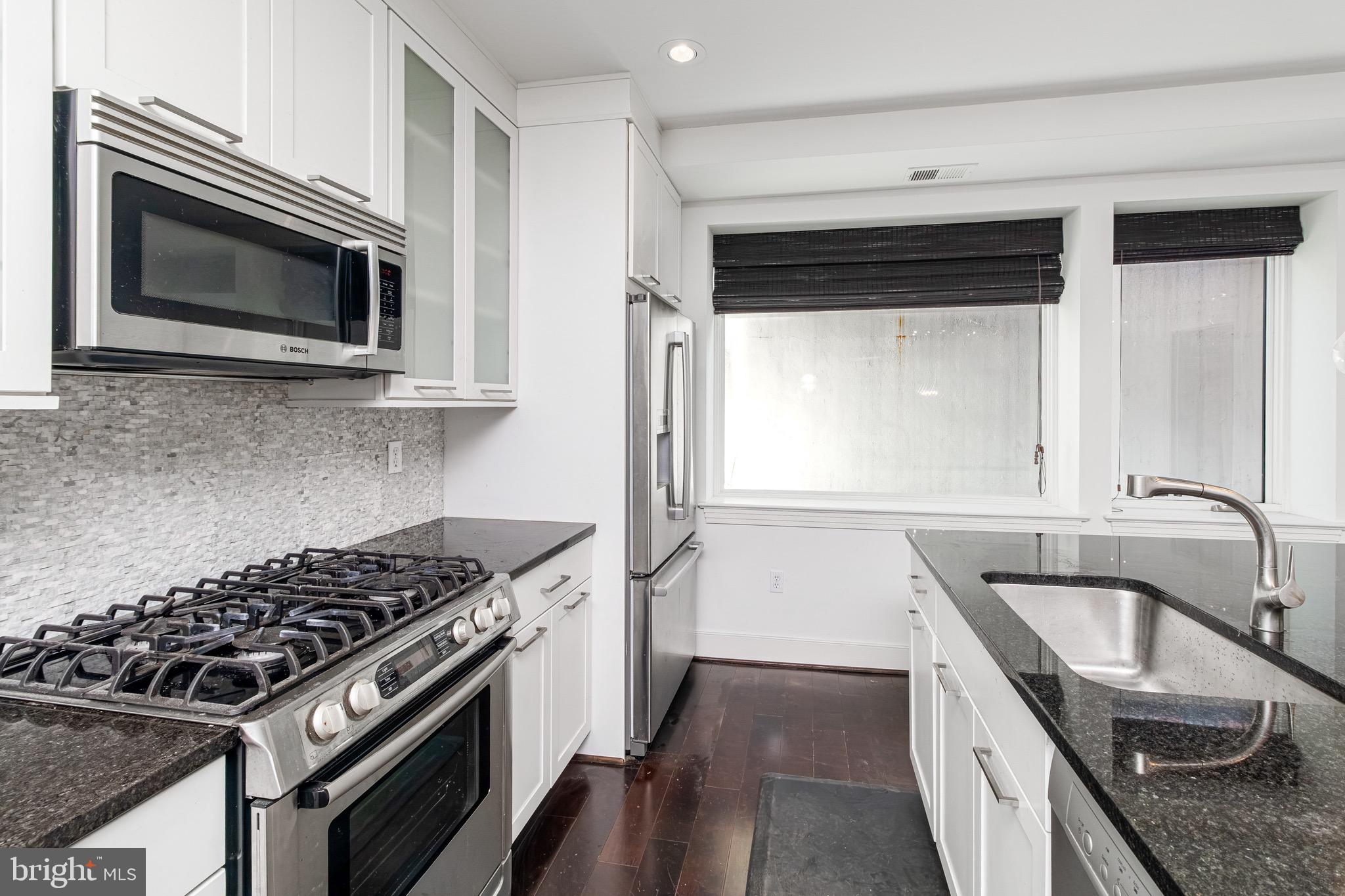 2360 Champlain Street Northwest, Unit B2 Washington, DC 20009 - Photo 8 of 10 a kitchen with granite countertop a sink stove and refrigerator