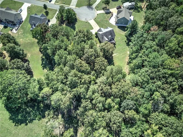 an aerial view of residential house with outdoor space and trees all around