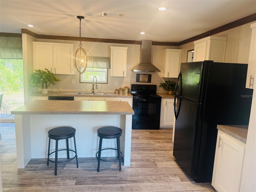 843 Southwest Central Terrace Fort White, FL 32038 - Photo 11 of 30 a kitchen with stainless steel appliances granite countertop a refrigerator a sink a stove a dining table and chairs