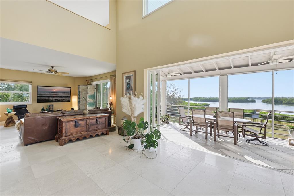 6511 Bayshore Road Palmetto, FL 34221 - Photo 14 of 53 a living room with furniture a flat screen tv and large windows