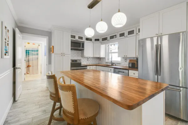 a kitchen with kitchen island granite countertop a sink cabinets and stainless steel appliances