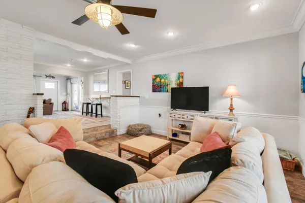 a living room with furniture kitchen and a flat screen tv