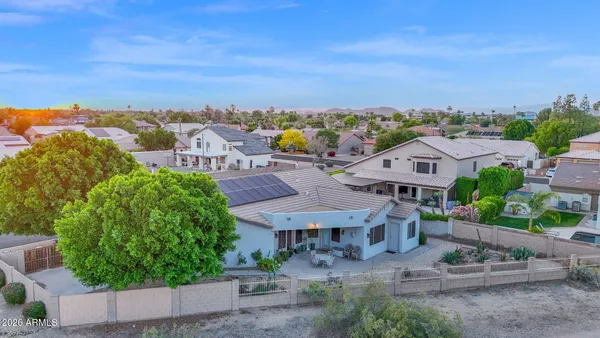 an aerial view of residential houses with outdoor space and trees