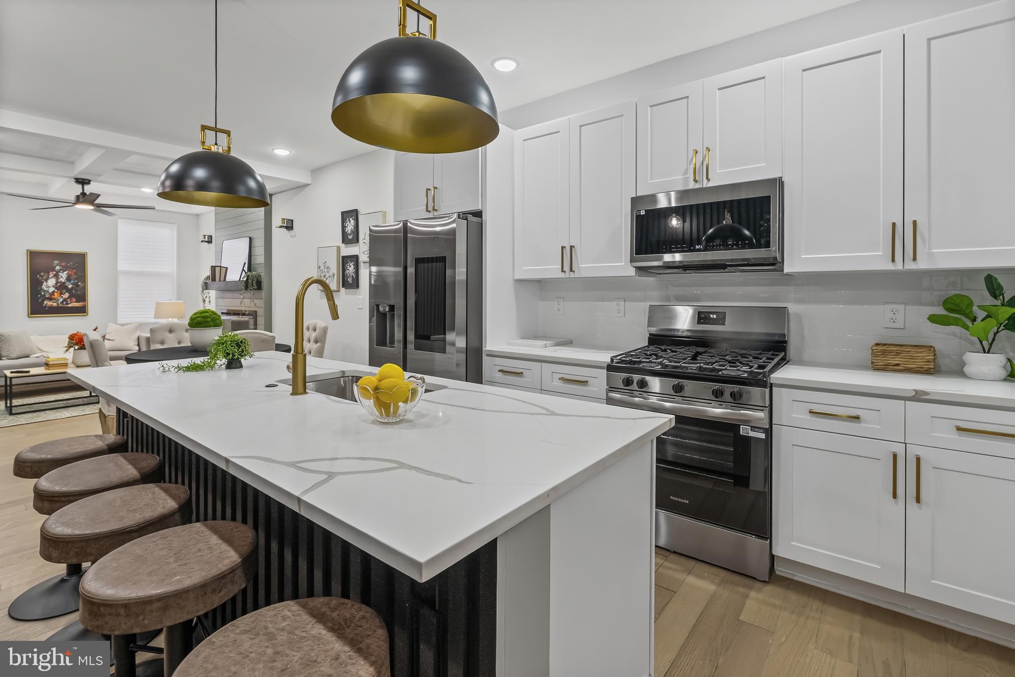 a kitchen with stainless steel appliances a stove a microwave a dining table and chairs