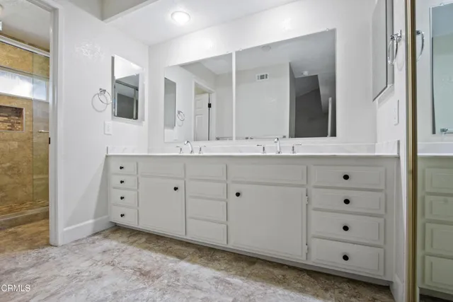 a bathroom with a double vanity sink and mirror