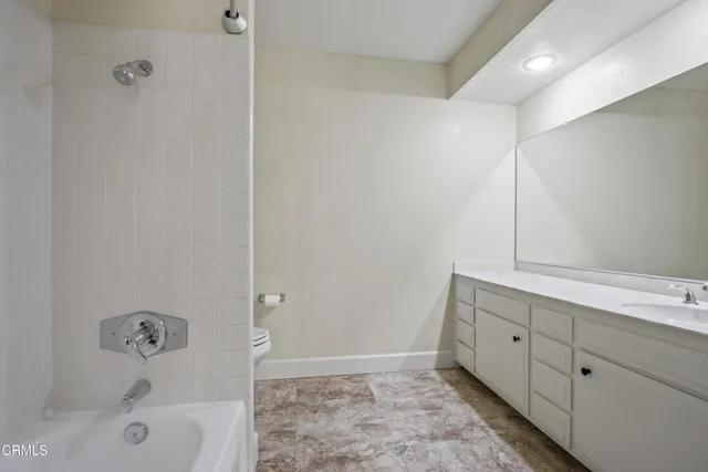 a bathroom with a tub sink and mirror