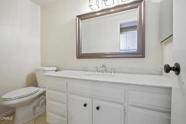 a bathroom with a toilet sink vanity and mirror