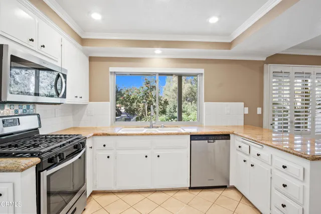 a kitchen with granite countertop white cabinets and white appliances