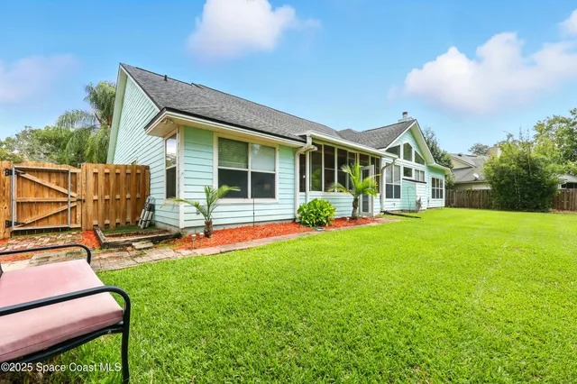 a view of a house with a big yard and large trees