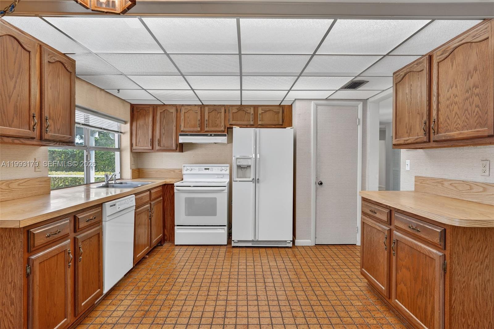 10753 Southwest 118th Street Miami, FL 33176 - Photo 12 of 51 a kitchen with a sink a refrigerator and cabinets