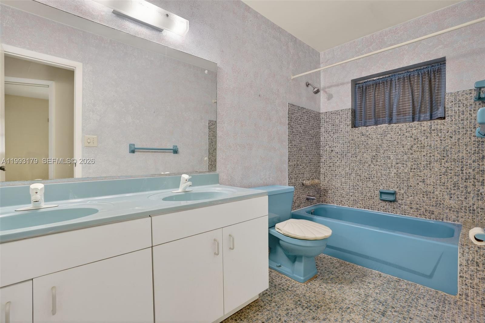 10753 Southwest 118th Street Miami, FL 33176 - Photo 29 of 51 a bathroom with a granite countertop sink a toilet a mirror and a bathtub