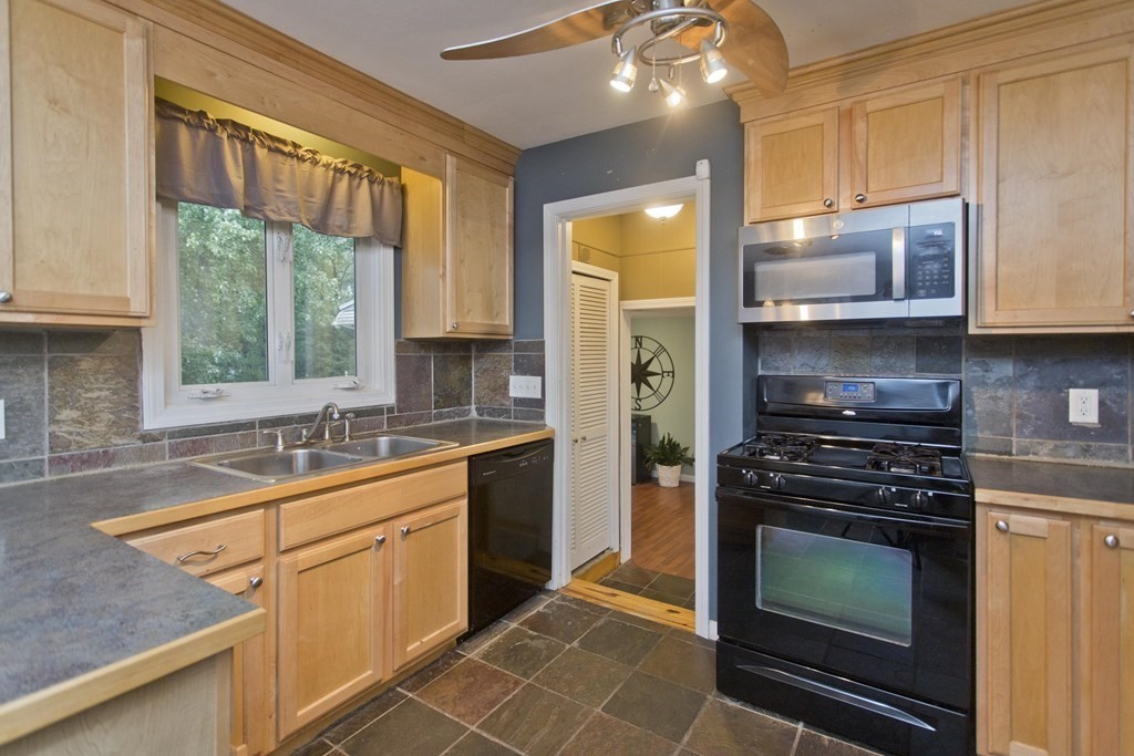 73 Bremen Street Springfield, MA 01108 - Photo 14 of 42 a kitchen with stainless steel appliances granite countertop a stove a sink and a microwave