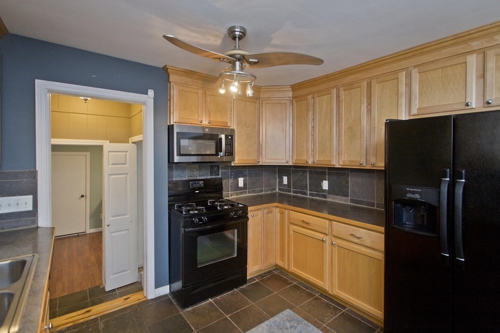 73 Bremen Street Springfield, MA 01108 - Photo 16 of 42 a kitchen with a sink a refrigerator and cabinets