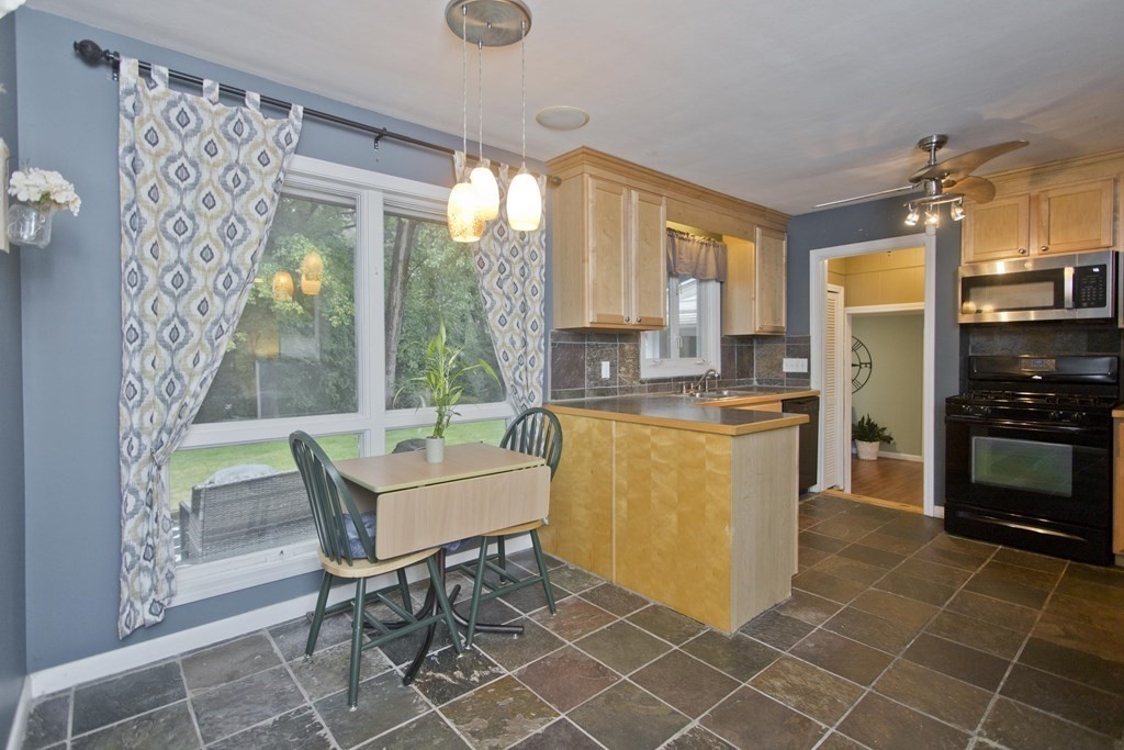 73 Bremen Street Springfield, MA 01108 - Photo 17 of 42 a kitchen with a table chairs and a refrigerator