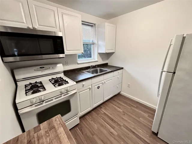 a kitchen with granite countertop a sink and a stove top oven