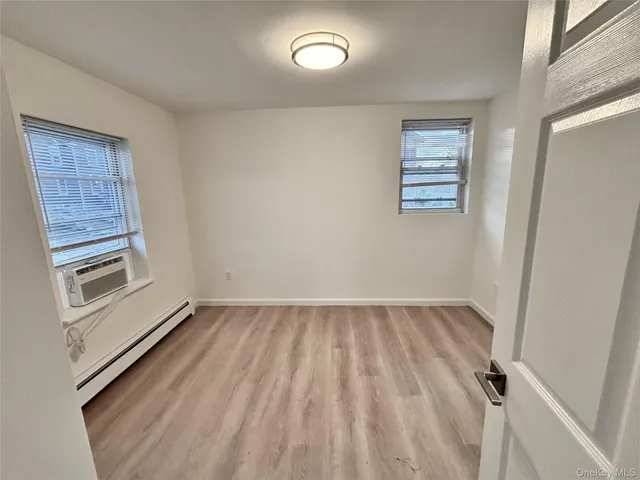 a view of a room with wooden floor and white walls