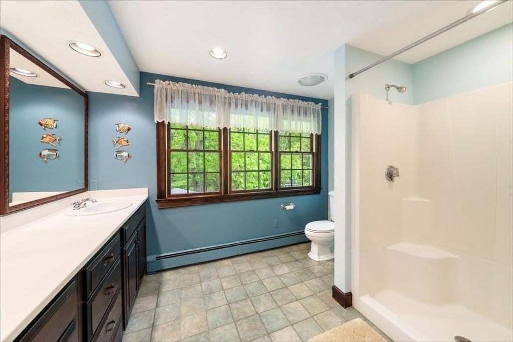 94 Middleton Road Boxford, MA 01921 - Photo 28 of 36 a bathroom with a granite countertop sink toilet a large mirror next to a window