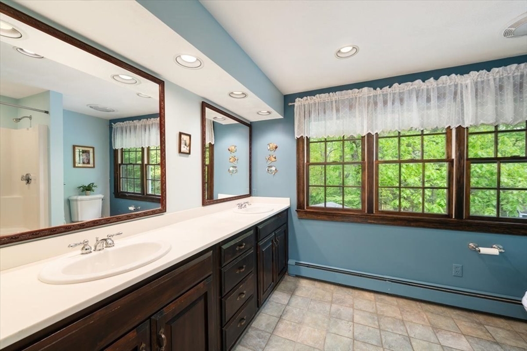 94 Middleton Road Boxford, MA 01921 - Photo 29 of 36 a spacious bathroom with a double vanity sink a large mirror and a bathtub