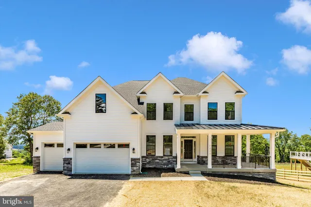 a view of a white house with swimming pool next to a yard