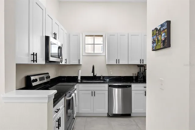 a view of a kitchen with cabinets and stainless steel appliances