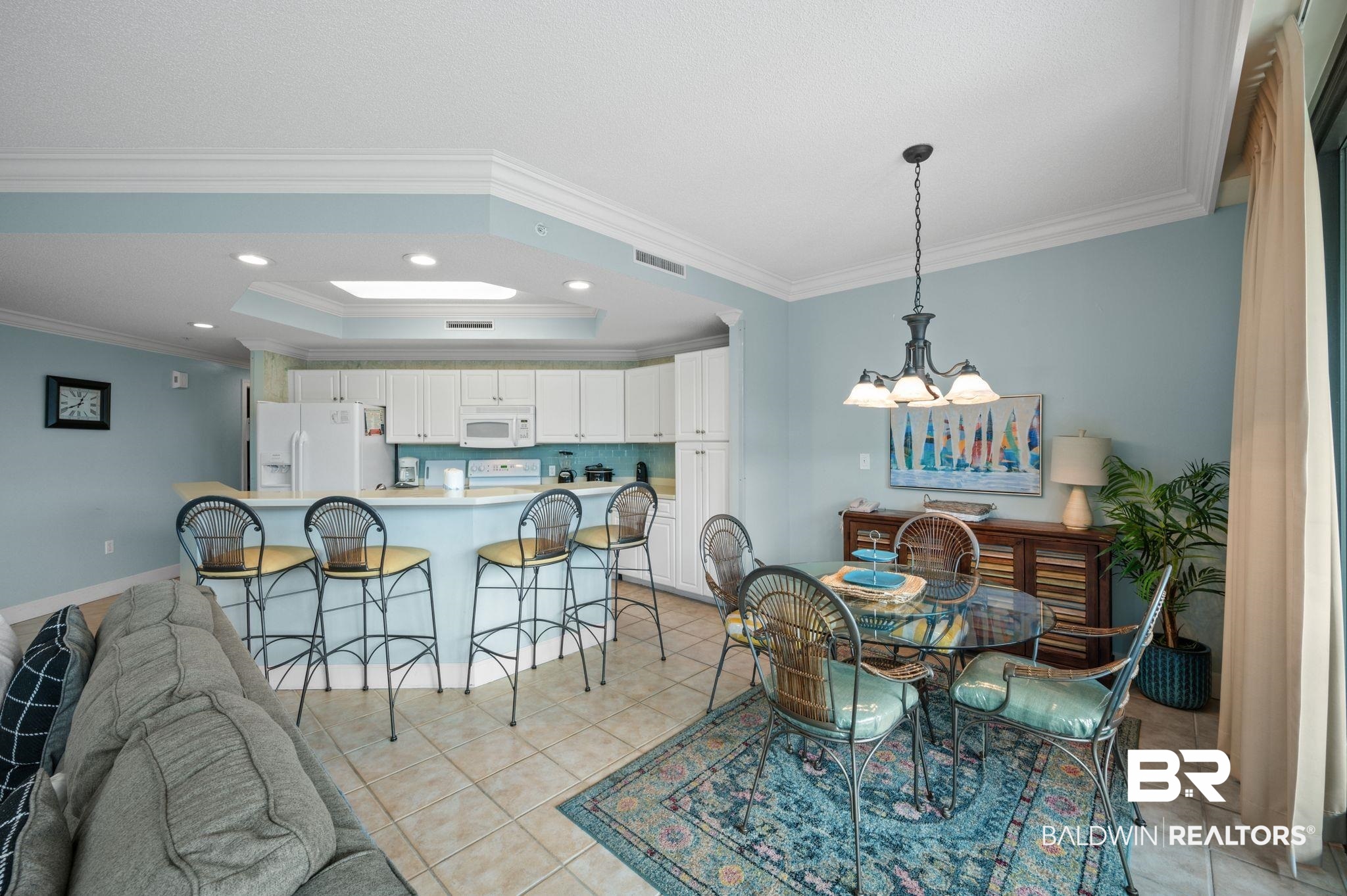 27580 Canal Road, Unit 1427 Orange Beach, AL 36561 - Photo 13 of 38 Dining space featuring hanging lights, a raised ceiling, crown molding, and light tile patterned floors