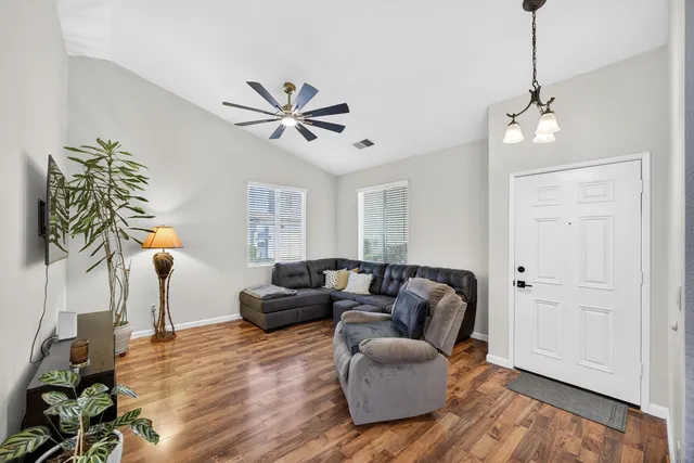 a living room with furniture and a wooden floor
