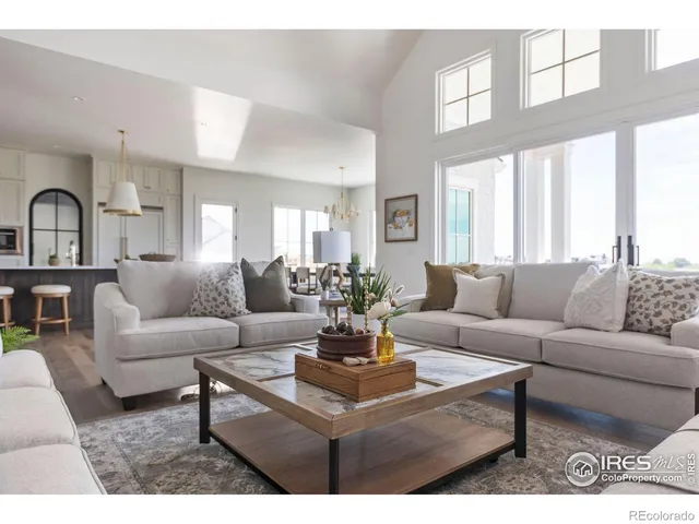 a living room with furniture a fireplace and a floor to ceiling window