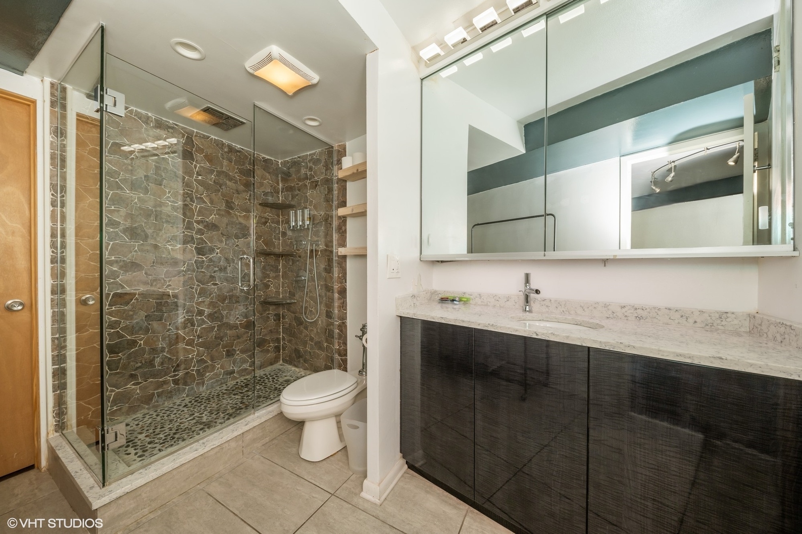 300 North State Street, Unit 5503 Chicago, IL 60654 - Photo 12 of 12 a bathroom with a shower sink vanity and toilet