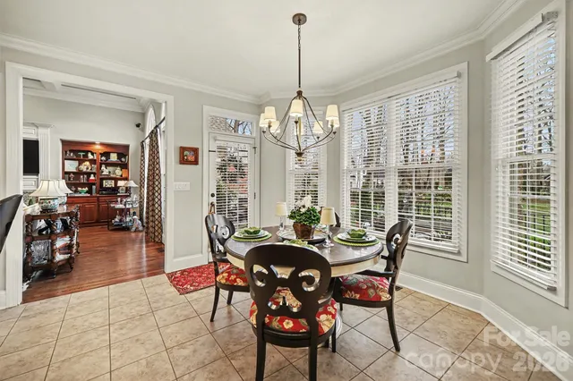 a dining room with furniture a chandelier and wooden floor