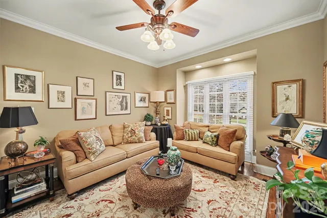 a living room with furniture a chandelier and a window