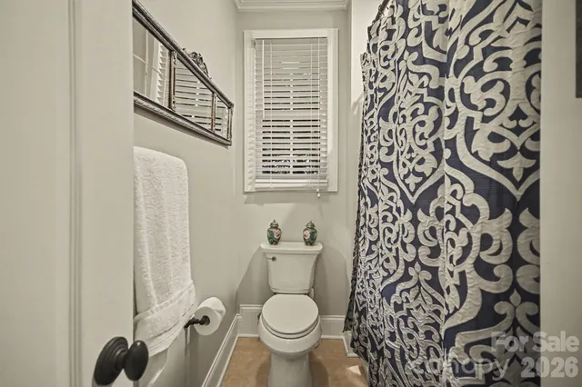 a bathroom with a toilet and a shower curtain
