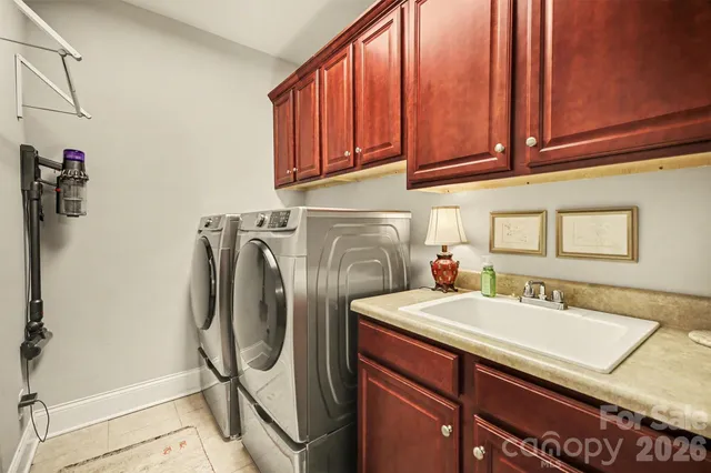 a utility room with sink dryer and washer